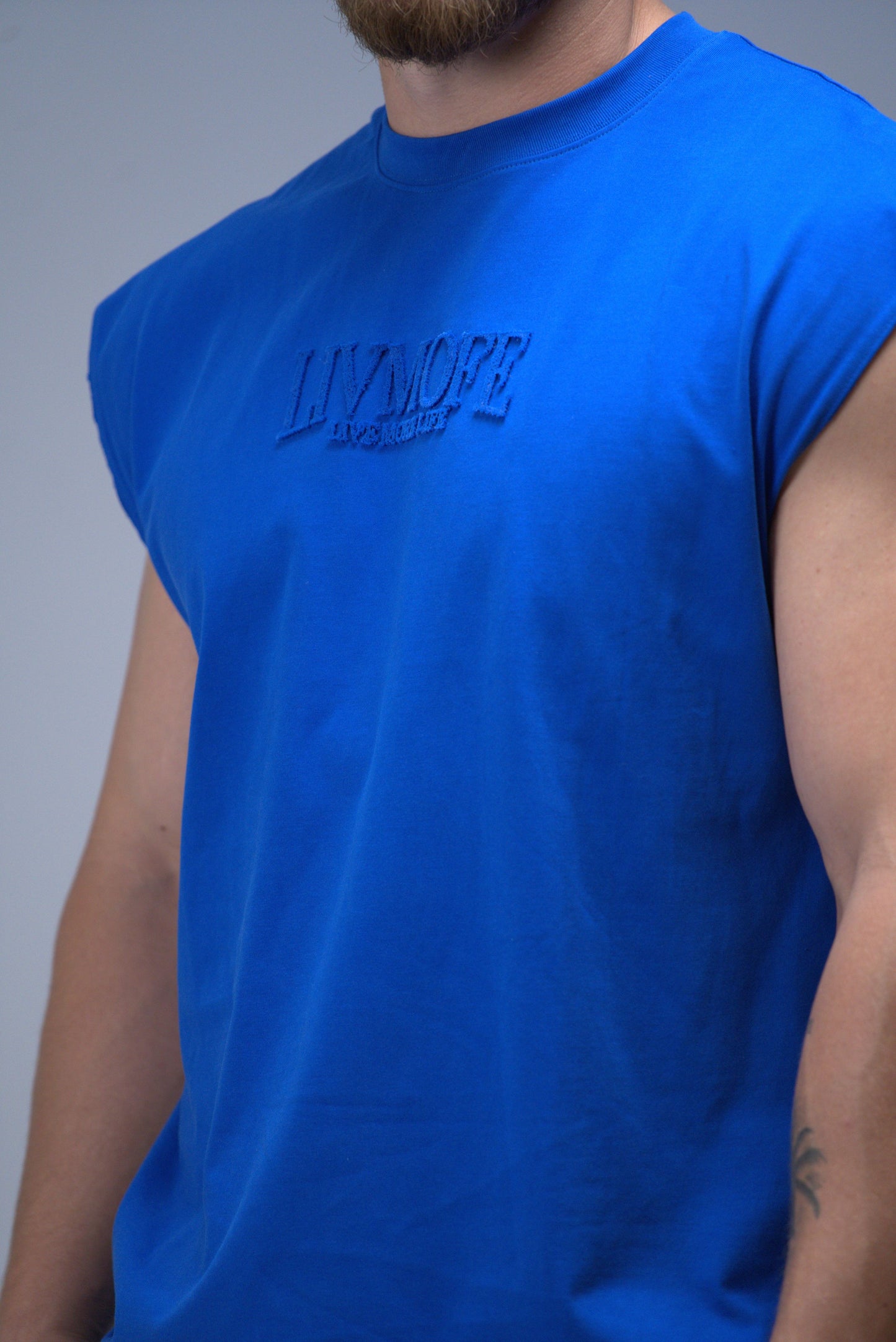 Blue sleeveless shirt with 'LIVMOFE' branding on a gray background