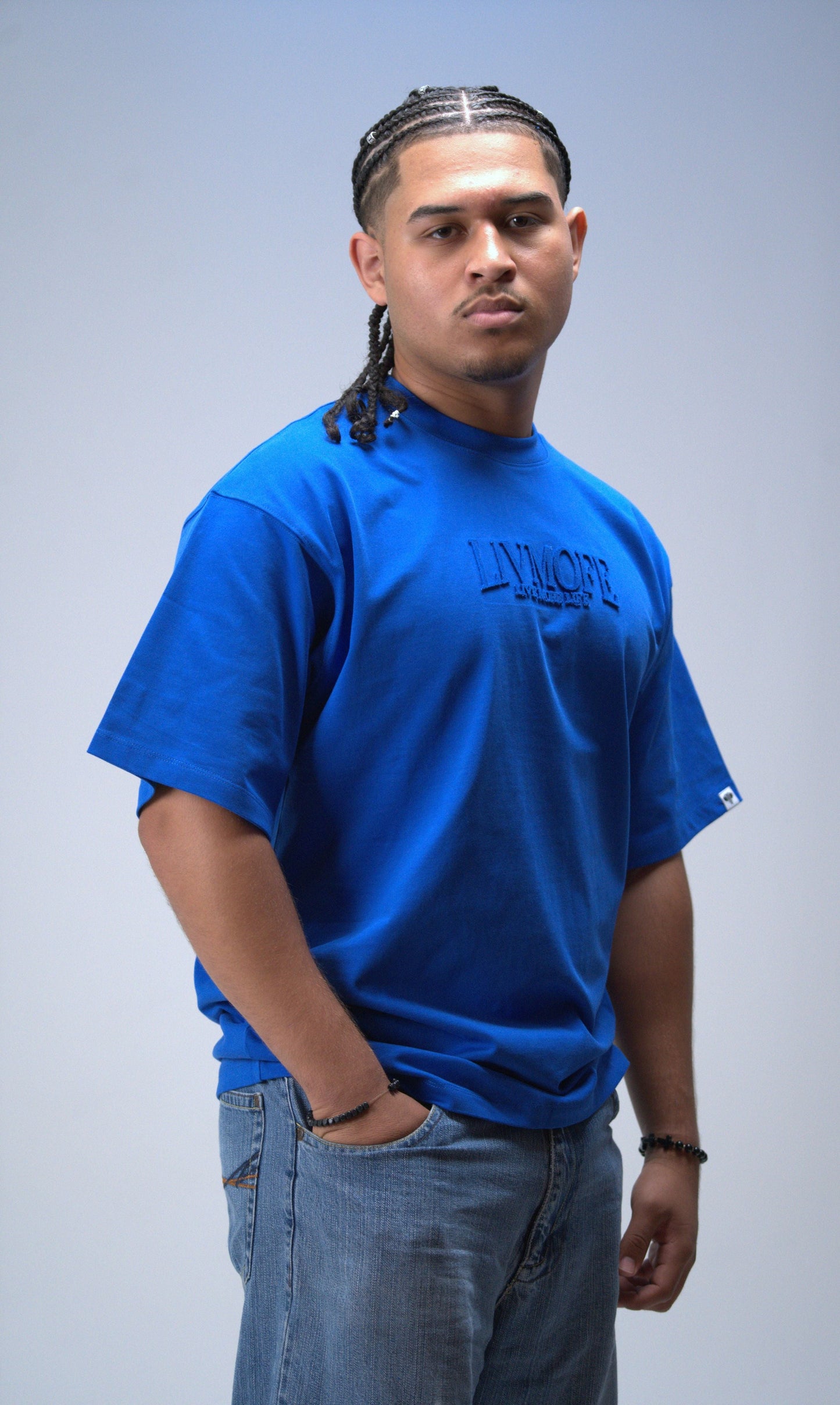 Man wearing a blue t-shirt with text on a plain background
