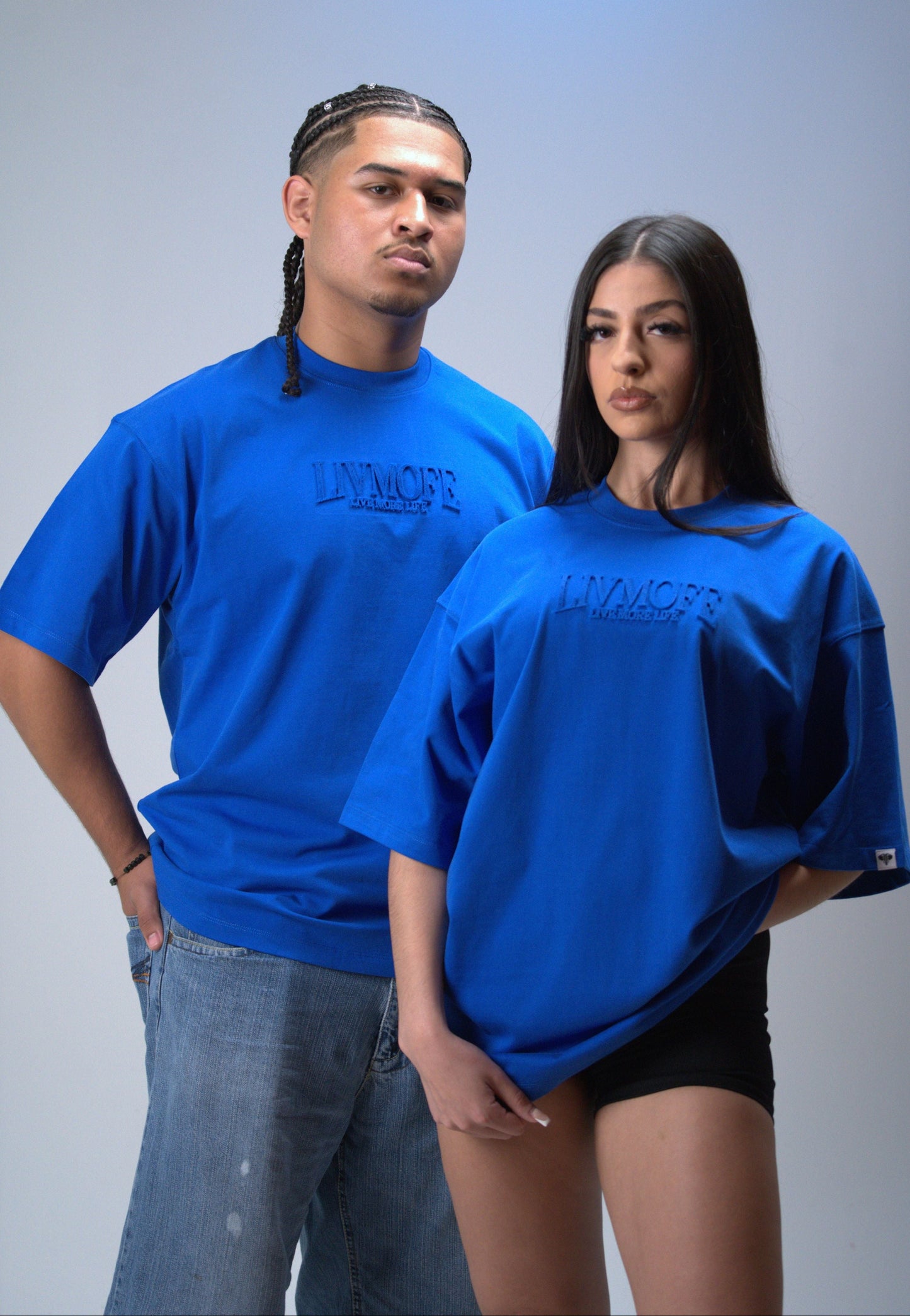 Two people wearing blue t-shirts with a brand logo
