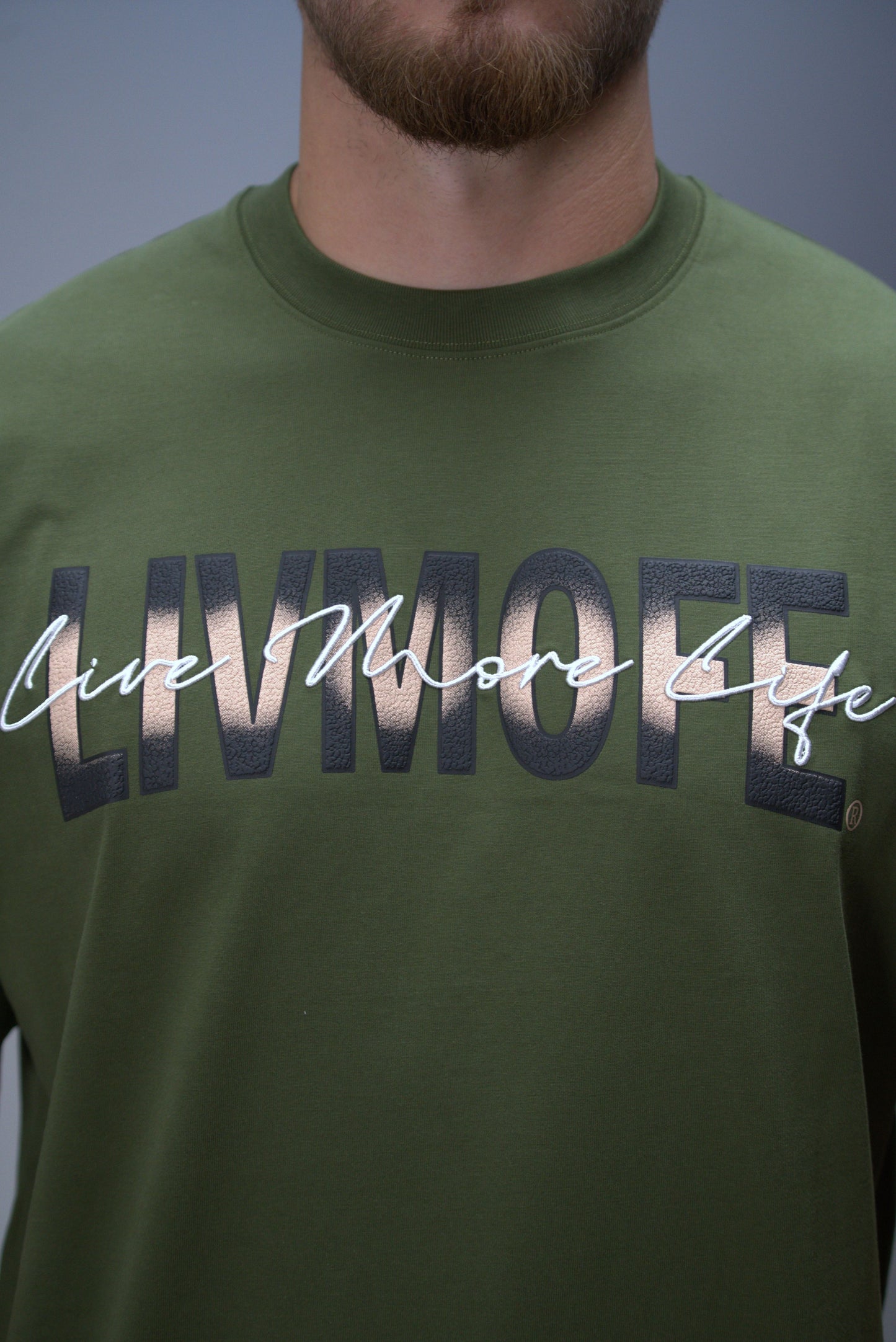 Green t-shirt with 'LIVE MORE LIFE' text worn by a person