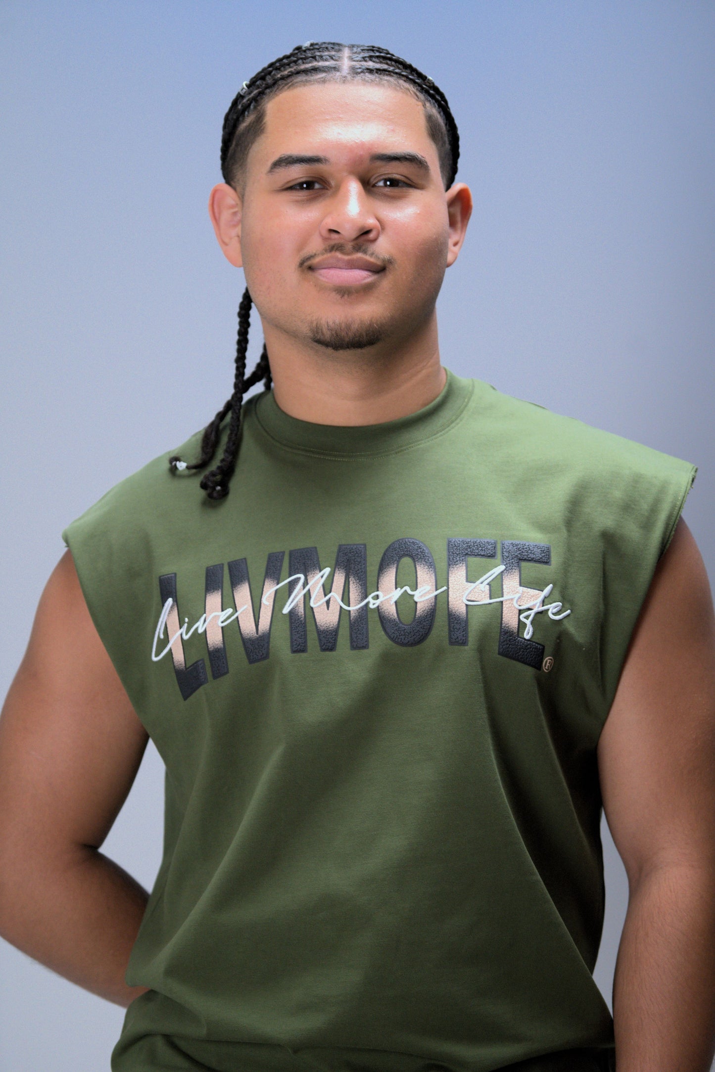 Man wearing a green sleeveless shirt with text on a plain background