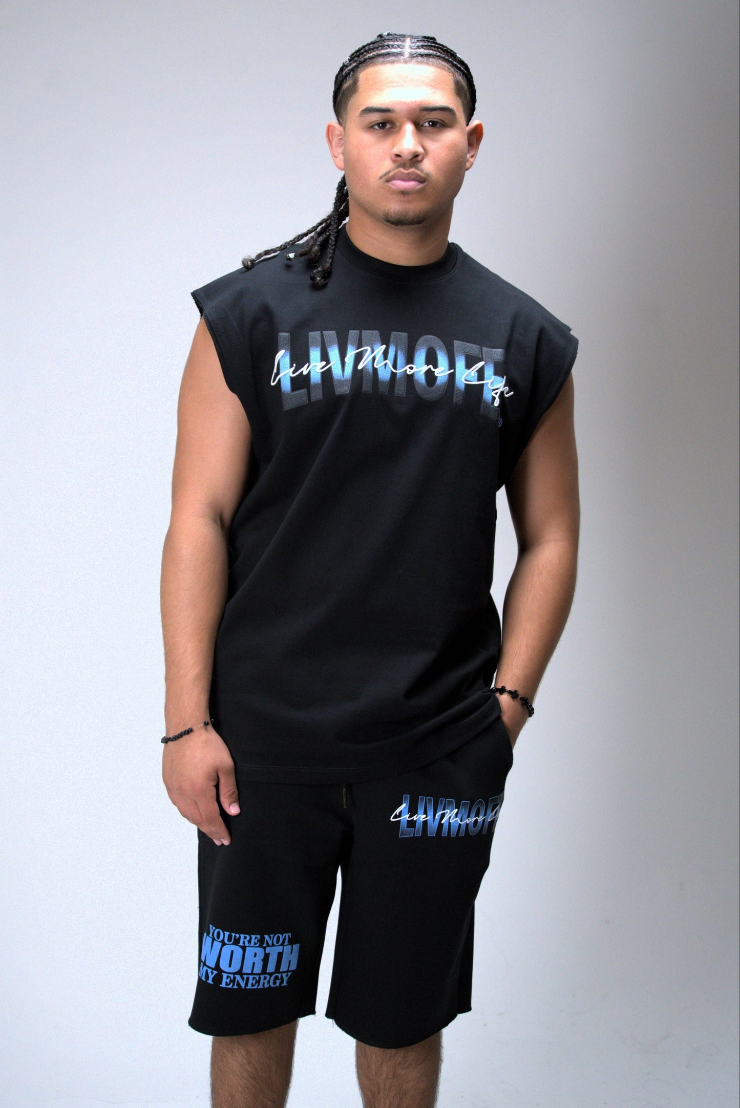 Person wearing a black sleeveless shirt and shorts with 'LIVMOFE' printed on them, standing against a gray background.