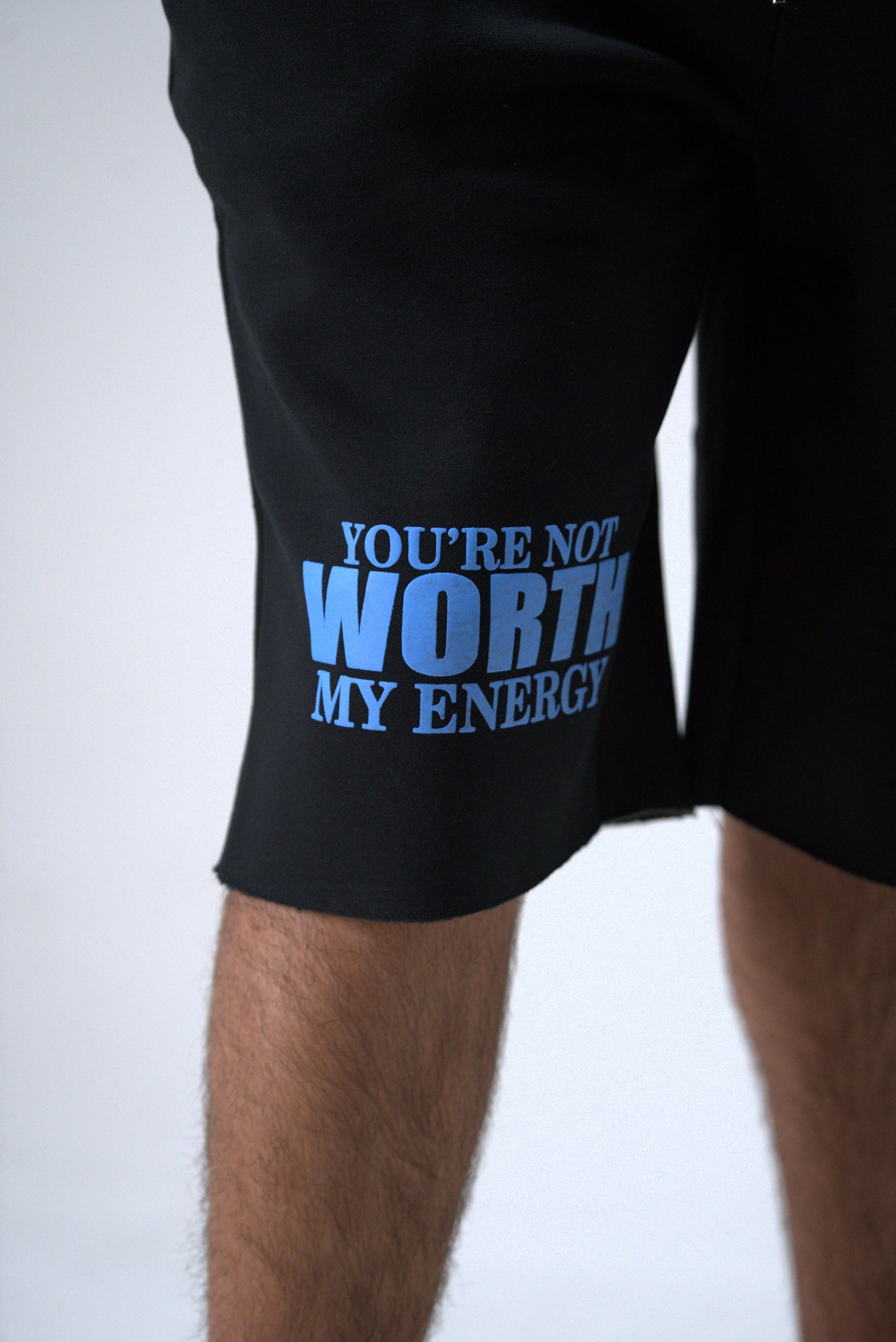 Black shorts with blue text 'YOU'RE NOT WORTH MY ENERGY' on a white background