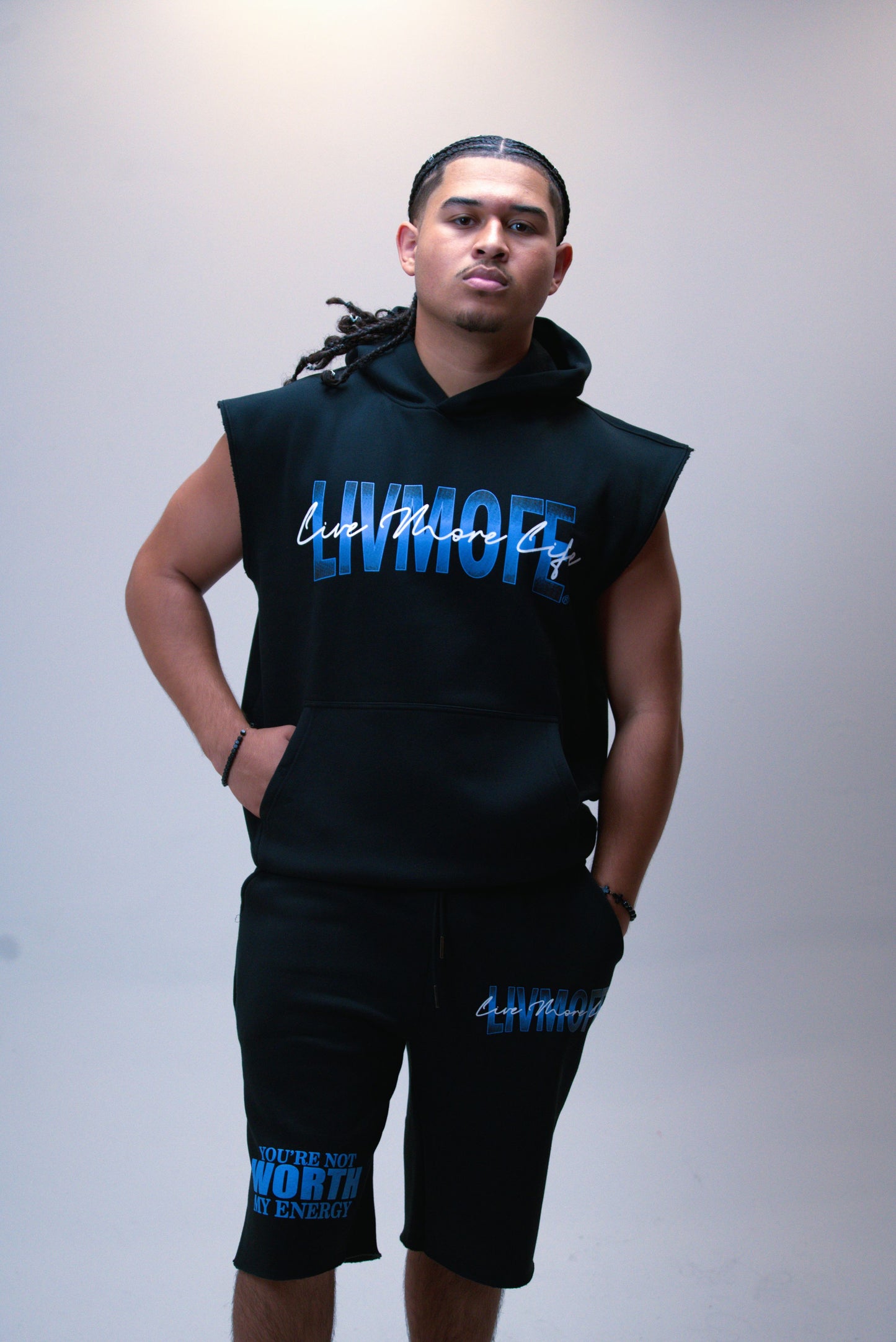 Person wearing a black sleeveless hoodie and shorts with 'LIVMOFE' branding on a plain background